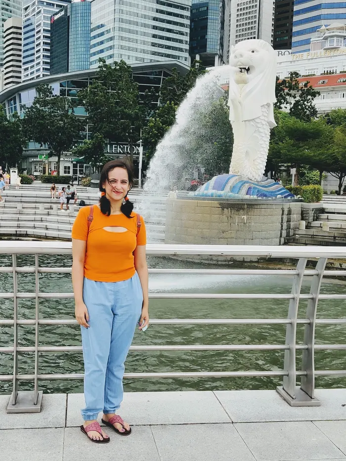 Megholova in front of the Merlion fountain, with the Singapore skyline behind