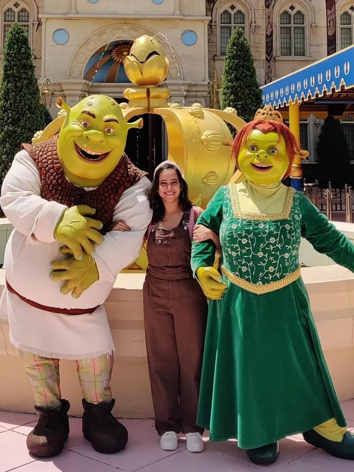 Megholova standing between Shrek and Fiona in front of a fountain at Universal Studios